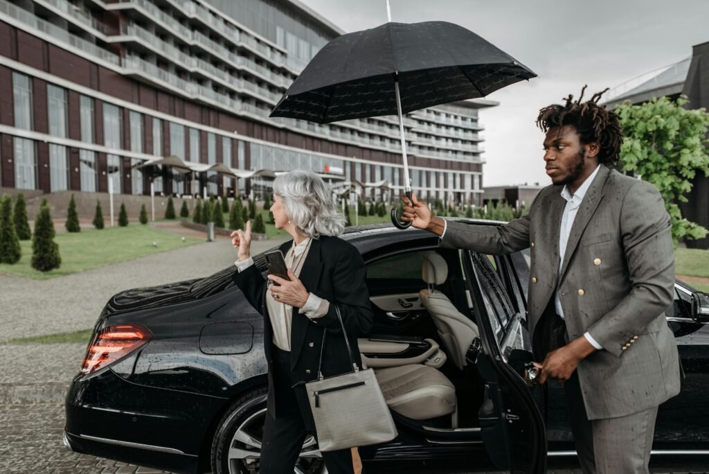 A Man in Gray Suit Assisting His Boss while Getting Out of the Car